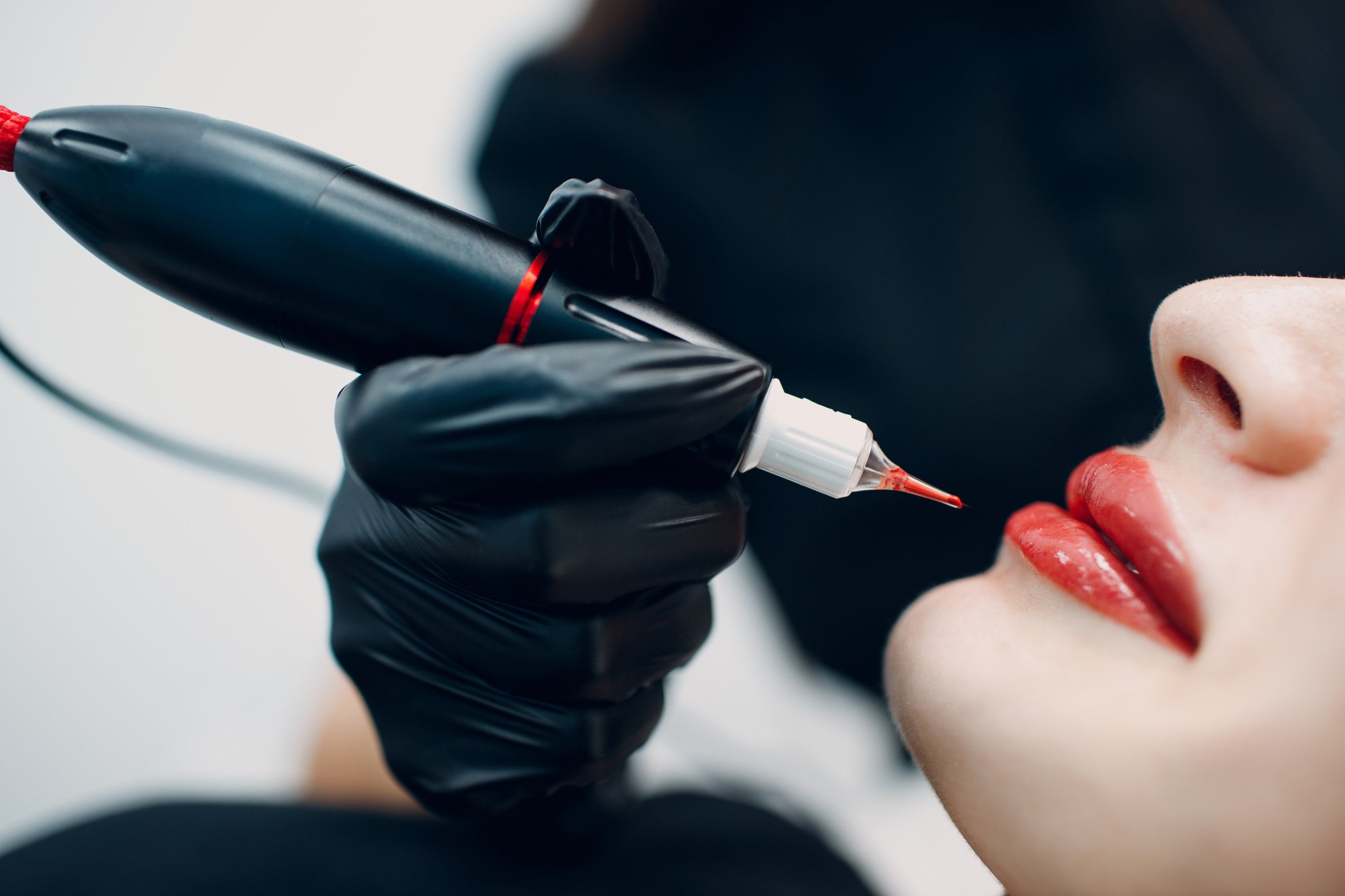 Cosmetologist Applying Red Permanent Make up Tattoo on Young Woman Lips